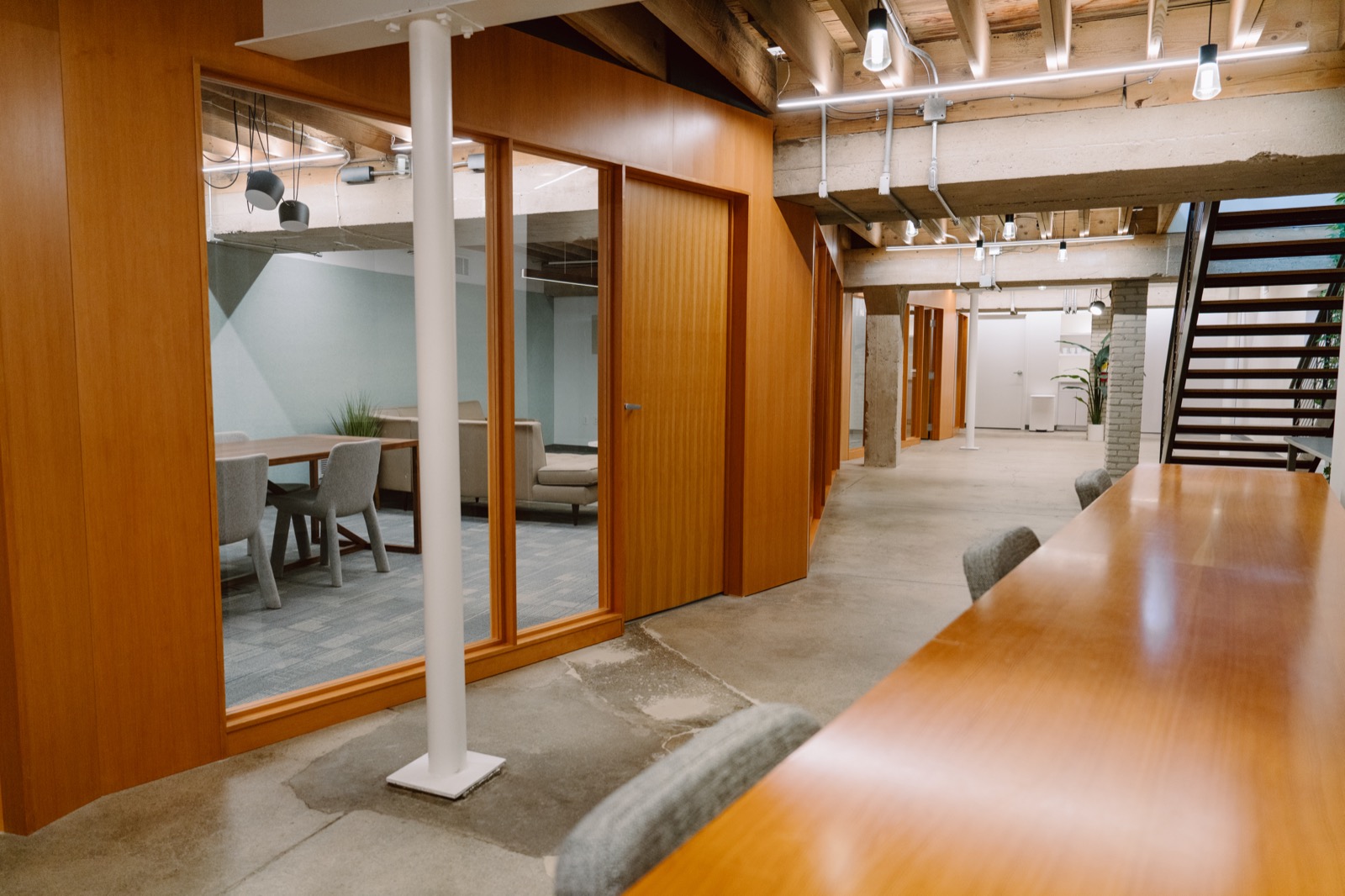 The corridor outside the rooms, with glass-walled meeting space and a long table